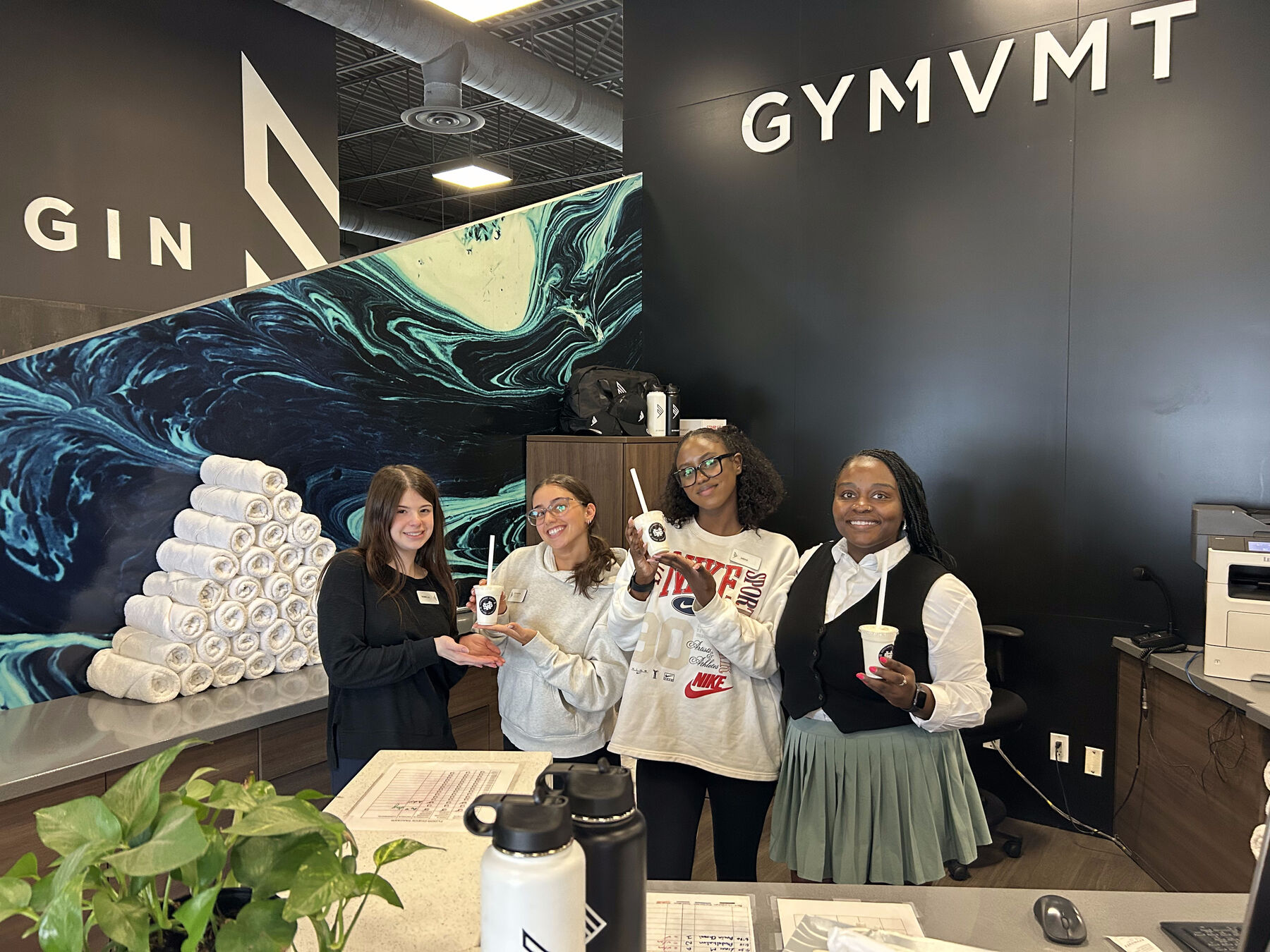 Staff at a north Edmonton gym holding Supplement World shakes during a community shake drop off